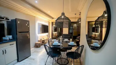 a kitchen and dining room with a table and a mirror at Appartement moderne terrasse avec baignoire privée in Marrakech