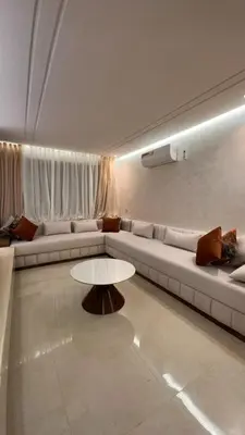 a living room with a couch and a table at Appartement luxueux avec piscine in Marrakech