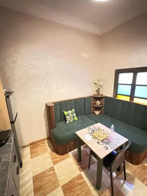 a living room with a green couch and a table at appartement pour famille in Marrakech