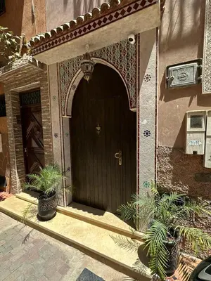 a brown door of a house with plants in front at appartement pour famille in Marrakech