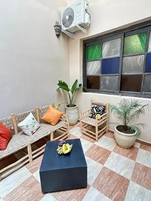 a patio with a couch and chairs and a table at appartement pour famille in Marrakech