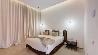 a bedroom with a bed with white walls and curtains at Ville d'Exception Marrakech in Marrakech