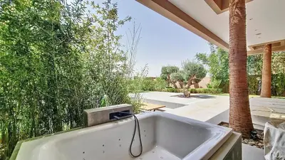 a bath tub with a hose in a yard at Ville d'Exception Marrakech in Marrakech