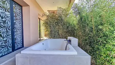 a white bath tub sitting next to a wall at Ville d'Exception Marrakech in Marrakech