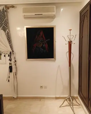 a white wall with a painting and a pole on it at Kasbah Bastoff in Marrakech