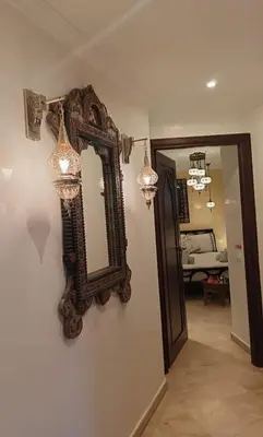 a mirror hanging on a wall next to a hallway at Kasbah Bastoff in Marrakech