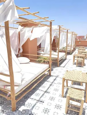 a row of beds with umbrellas on a roof at Appartement Luxe Gueliz Piscine & Spa in Marrakech