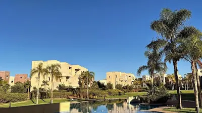a view of a resort with palm trees and a canal at La Perle de Marrakech in Marrakech