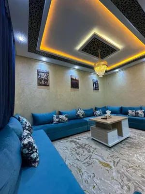 a living room with a blue couch and a table at appartement airport Marrakech in Marrakech