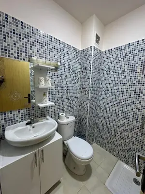 a bathroom with a white toilet and a sink at appartement airport Marrakech in Marrakech