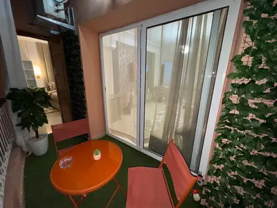 a room with a table and chairs and a large window at appartement de luxe dans le centre de marrakech in Marrakech