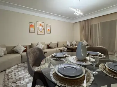 a living room with a table and a couch at appartement de luxe dans le centre de marrakech in Marrakech