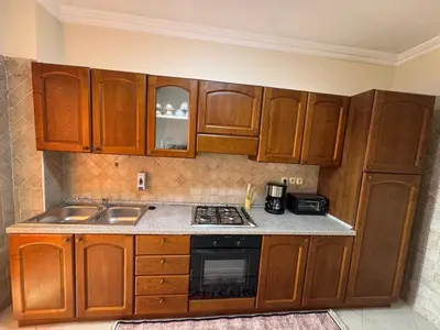 a kitchen with wooden cabinets and a stove top oven at appartement de luxe dans le centre de marrakech in Marrakech