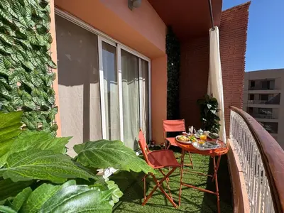 a patio with a table and chairs on a balcony at appartement de luxe dans le centre de marrakech in Marrakech