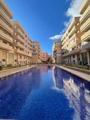 a large swimming pool in the middle of a building at Elegant 2 bedroom apartment in Palmeraie Gates in Marrakech
