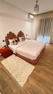 a bedroom with a large bed with a large headboard at Elegant 2 bedroom apartment in Palmeraie Gates in Marrakech