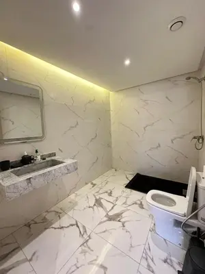 a white bathroom with a sink and a toilet at Elegant 2 bedroom apartment in Palmeraie Gates in Marrakech
