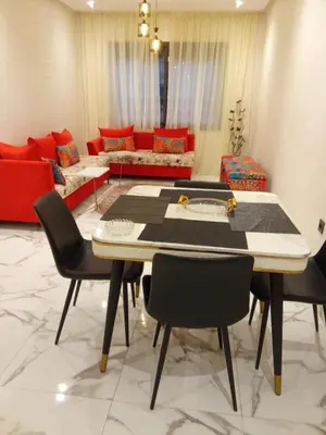 a living room with a table and chairs and a couch at Elegant 2 bedroom apartment in Palmeraie Gates in Marrakech