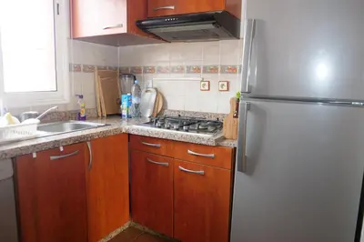 a kitchen with wooden cabinets and a refrigerator at Calm Spacious Family Apartment Close To Coty in Marrakech