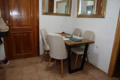 a dining room table with white chairs and two mirrors at Calm Spacious Family Apartment Close To Coty in Marrakech