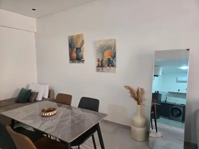 a dining room with a table with chairs and paintings at luxury apartment in Marrakech center in Marrakech