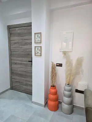 a living room with two vases and a door at luxury apartment in Marrakech center in Marrakech