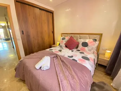 a bedroom with a bed with shoes on it at Small Cosy & Balcon & Vue Palmier et Montagne in Marrakech