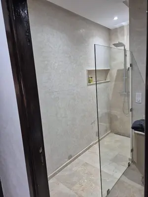 a shower with a glass door in a bathroom at Jennaya - Appartement moderne, élégant et raffiné in Marrakech