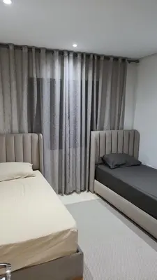 a bedroom with two beds and a window with curtains at Jennaya - Appartement moderne, élégant et raffiné in Marrakech
