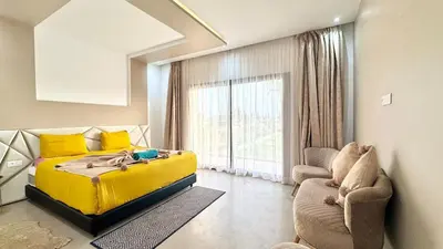 a bedroom with a yellow bed and a couch at New Villa Dali & Spa Paddel Marrakech in Marrakech