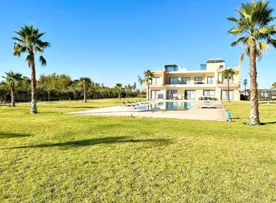 a large house with palm trees in front of it at New Villa Dali & Spa Paddel Marrakech in Marrakech