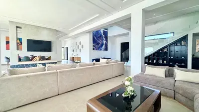 a living room with a large couch and a table at New Villa Dali & Spa Paddel Marrakech in Marrakech