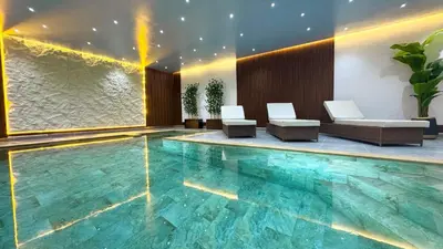 a swimming pool with two chairs and a table at New Villa Dali & Spa Paddel Marrakech in Marrakech