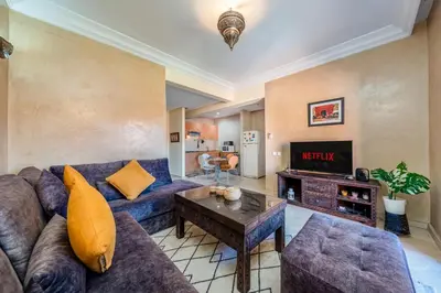 a living room with a couch and a table at Cocon Ocre Pool and Balcony in Marrakech