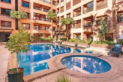a swimming pool in front of a building at Cocon Ocre Pool and Balcony in Marrakech