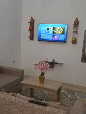 a living room with a couch and a tv on a wall at appartement lady Plaza 2 in Marrakech