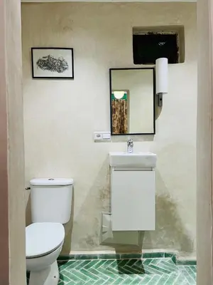 a bathroom with a white toilet and a sink at Riad Dar L artiste in Marrakech