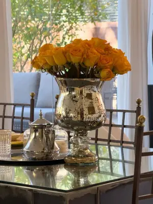 a vase filled with orange roses on a table at JARDIN VITTORIO - Marrakech - Hivernage - Heated & Luxury Pool in Marrakech