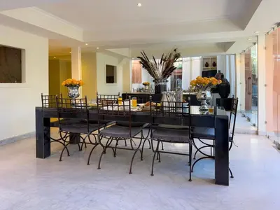 a dining room with a black table and chairs at JARDIN VITTORIO - Marrakech - Hivernage - Heated & Luxury Pool in Marrakech