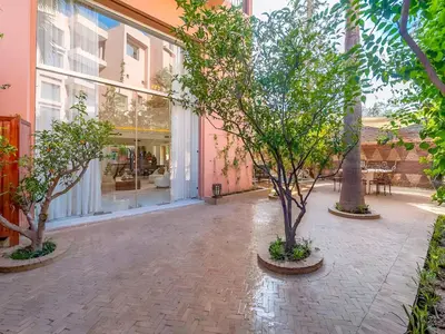 a courtyard with trees in front of a building at JARDIN VITTORIO - Marrakech - Hivernage - Heated & Luxury Pool in Marrakech