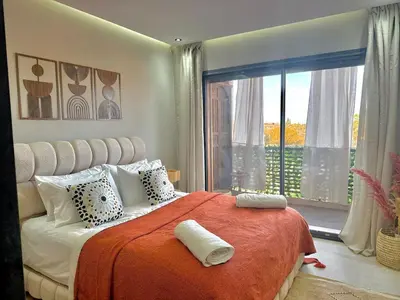 a bedroom with a large bed and a large window at Majorelle Luxury Studio in Marrakech