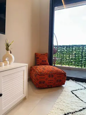 an orange chair sitting in a room with a window at Majorelle Luxury Studio in Marrakech
