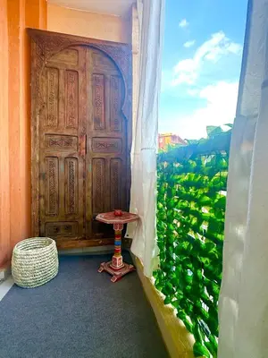 a large wooden door with a table in front of a window at Majorelle Luxury Studio in Marrakech