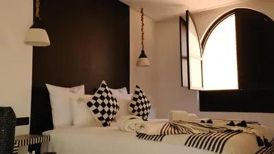 a bedroom with a bed with black and white pillows at Riad Dar Siyah in Marrakech
