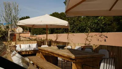 a wooden table and an umbrella on a patio at Riad Dar Siyah in Marrakech