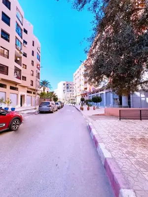 a street with cars parked on the side of the road at Elegant Guéliz Apartment in Marrakech