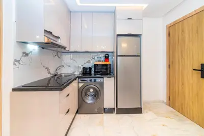 a kitchen with a refrigerator and a washing machine at Elegant Guéliz Apartment in Marrakech