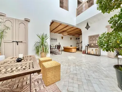 a living room with a table and a fireplace at Maison Remedy et Spa Private Pool & Breakfast in Marrakech