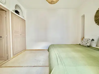 a bedroom with a green bed and a white wall at Maison Remedy et Spa Private Pool & Breakfast in Marrakech