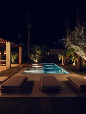 a swimming pool at night with two loungers in front at LA VILLA 58 - Ecolodge - Marrakech in Marrakech